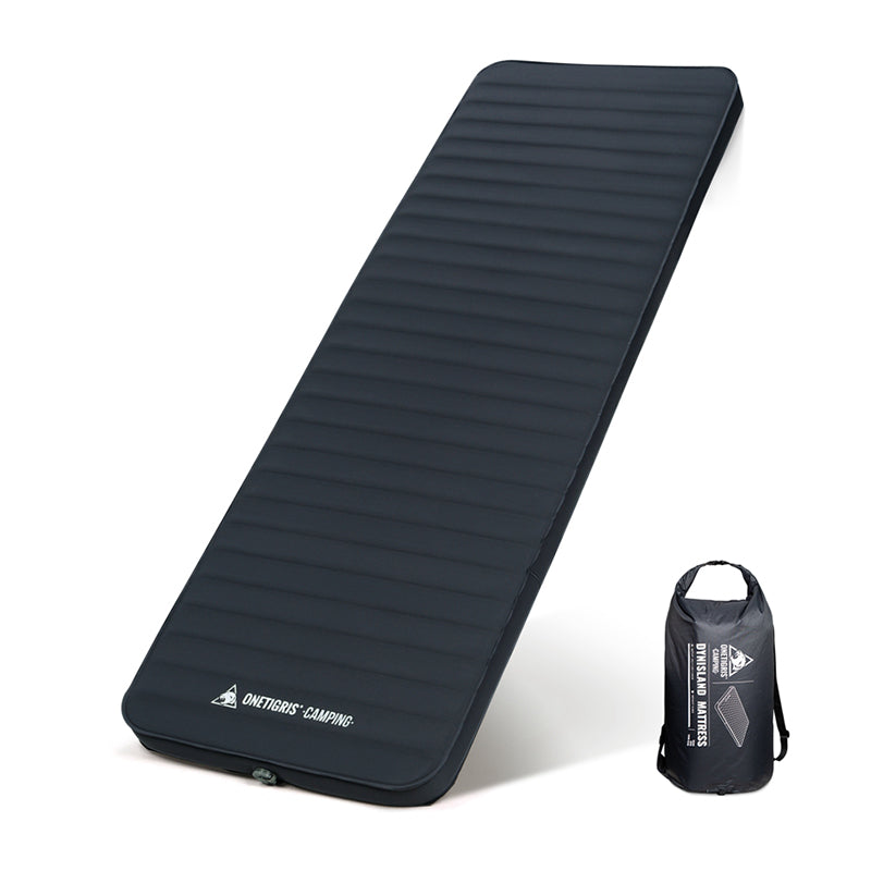 A black OneTigris DREAMSTAR sleeping pad unfolded and laid flat next to its inflation sack.