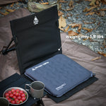 Camping chair with cushion on a camping mat, surrounded by nature.