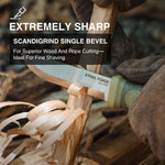 Knife with scandigrind single bevel technology cutting wood, with 'Trail Forge' branding.