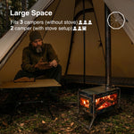 Man sitting by a tent with a stove setup, indicating space for multiple campers.