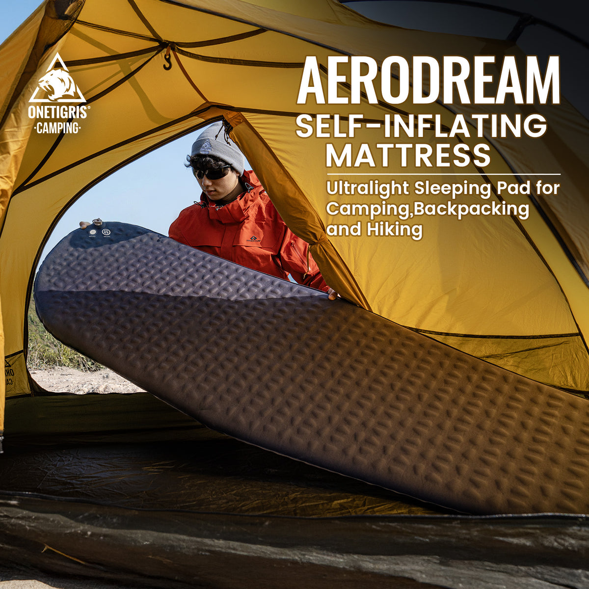 Aerodream self-inflating mattress displayed in front of a yellow tent with a person peeking out.