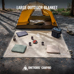 Large outdoor blanket with camping gear on a gravel surface, featuring the OneTigris Camping brand.