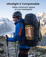 Man hiking with an ultralight and compressible backpack in a mountainous landscape
