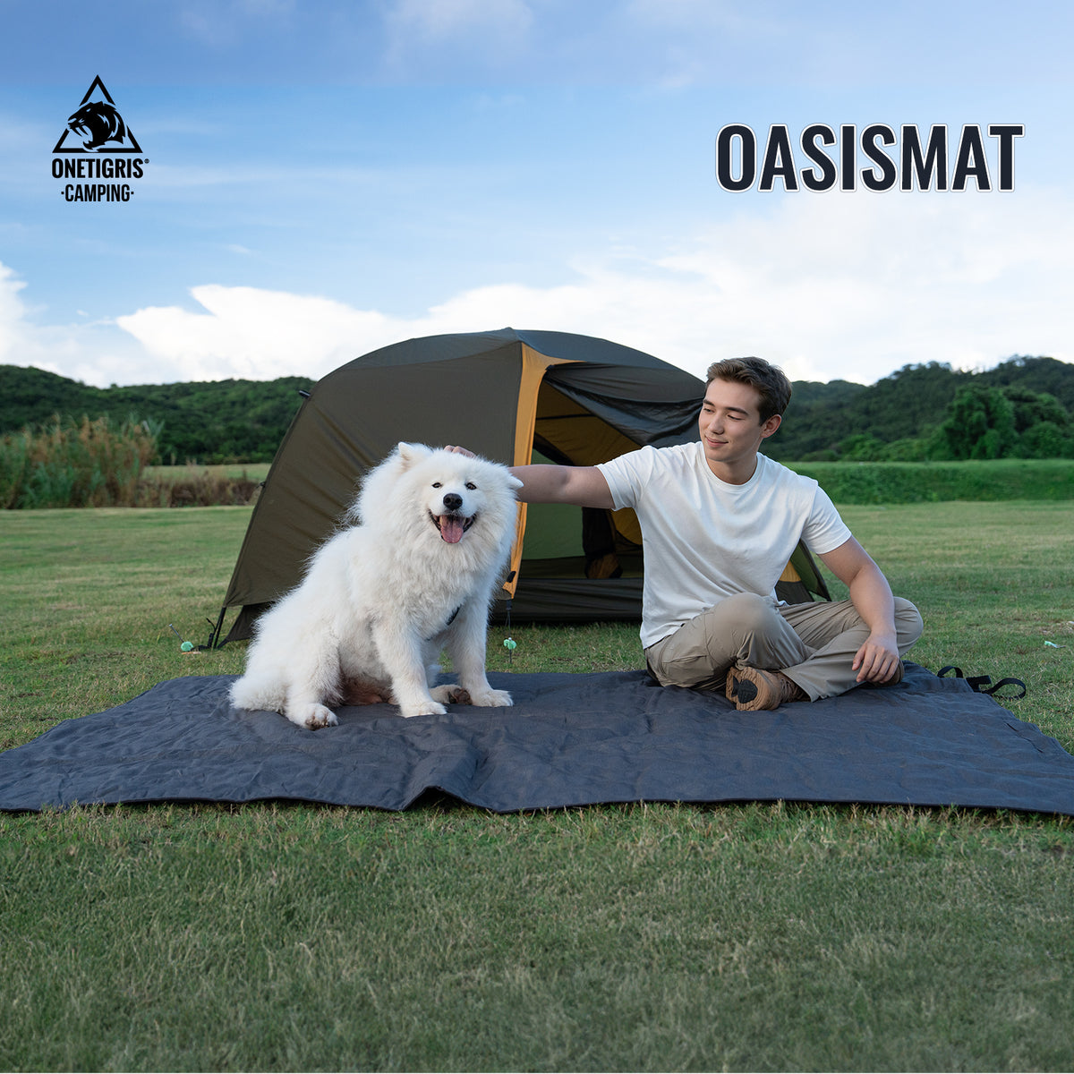 Person with a dog on an OASISMAT camping mat in a grassy field with a tent in the background.