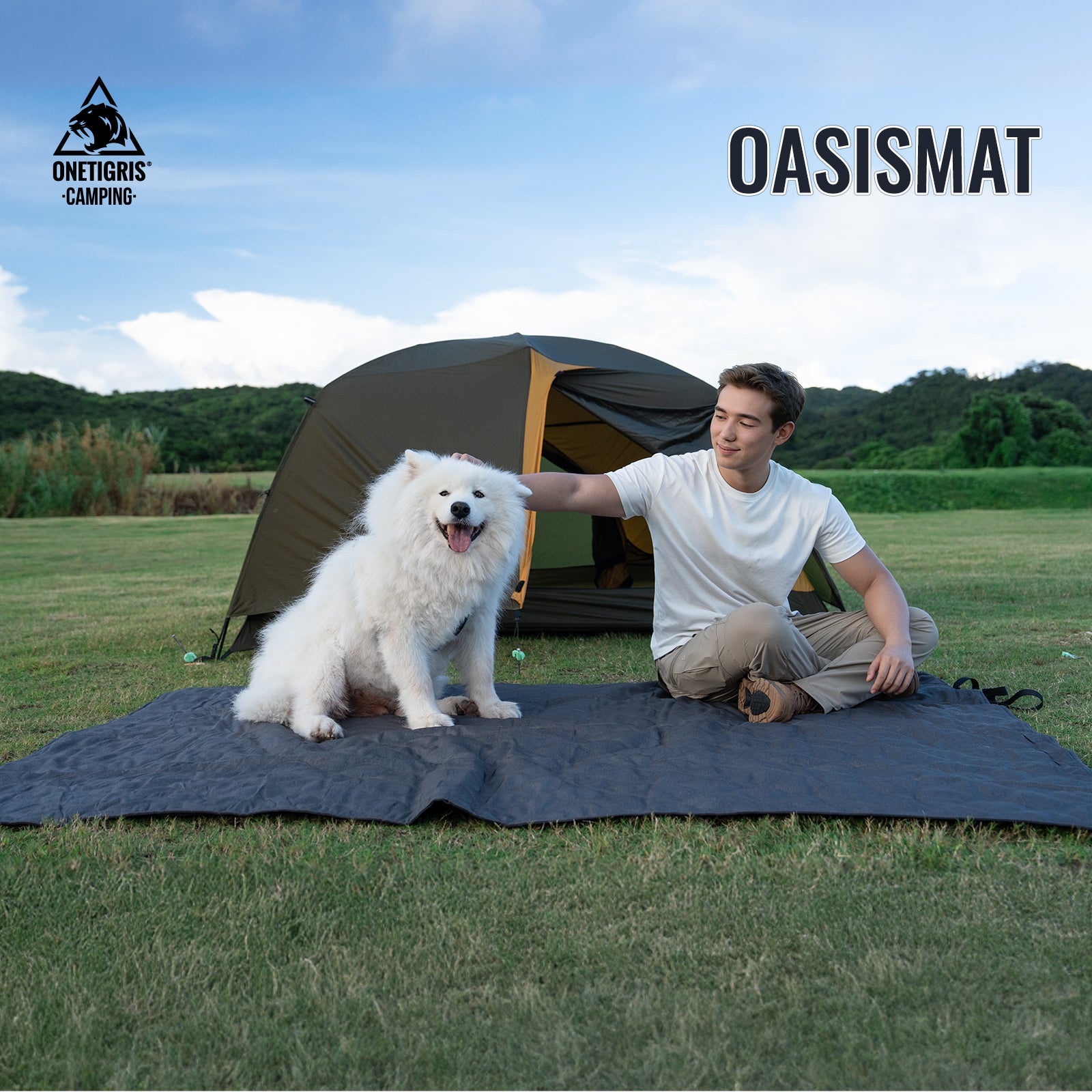 Person with a dog on an OASISMAT camping mat in a grassy field with a tent in the background.