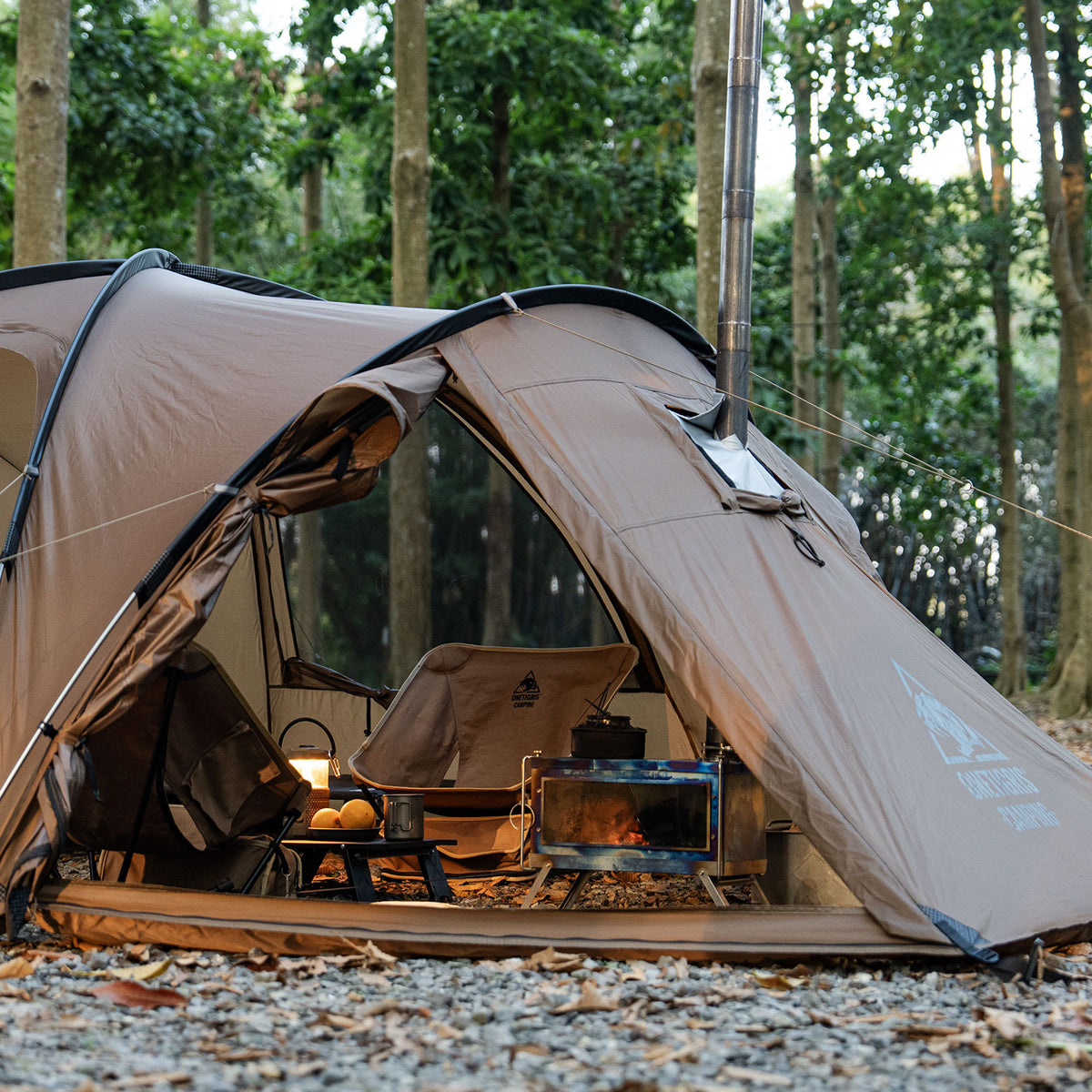 ORBITIS Camping Tent with a stove and cooking area set up in a forest