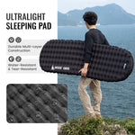 Person holding an ultralight sleeping pad with scenic background