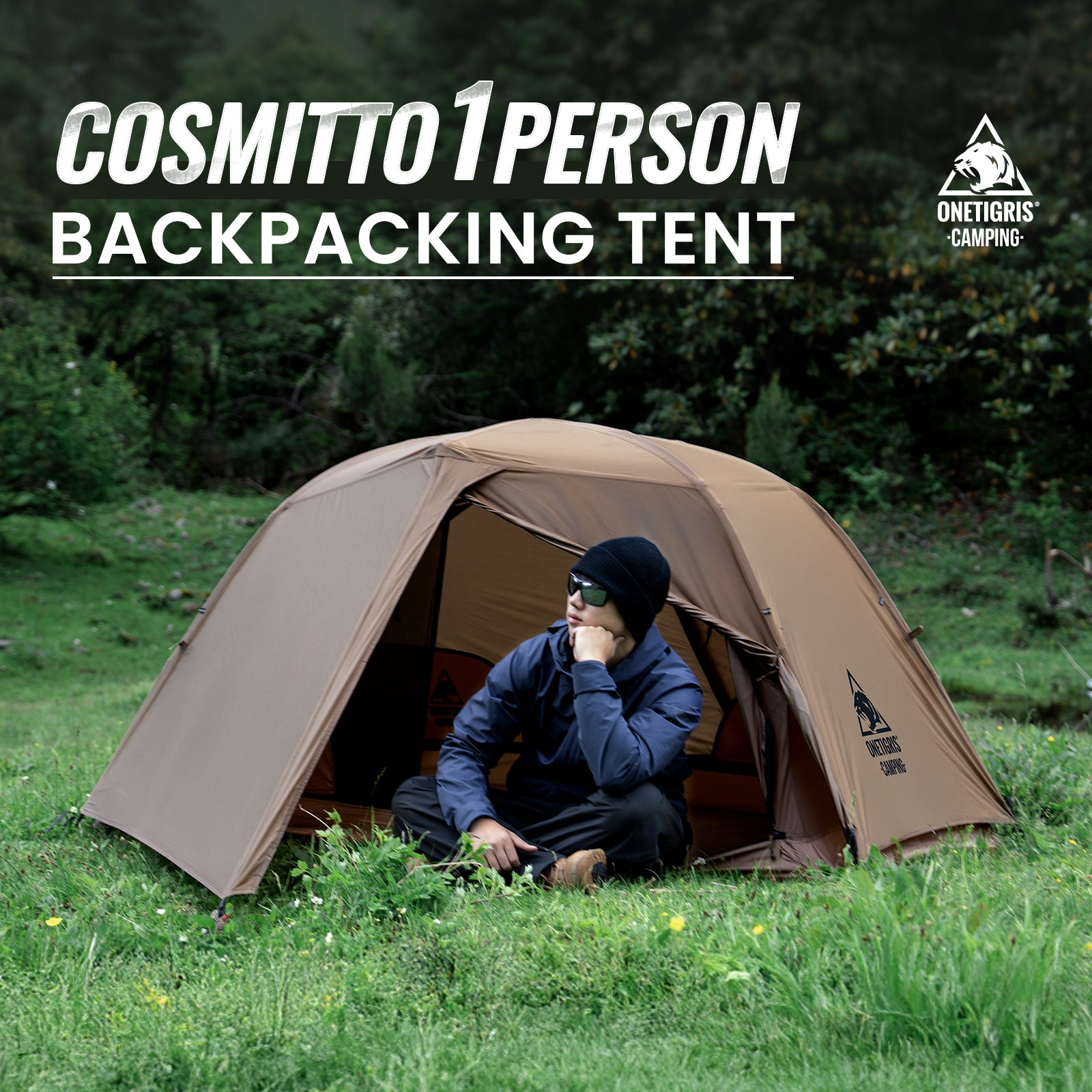 Person sitting inside a brown Cosmitto 1-person backpacking tent in a grassy area with trees.