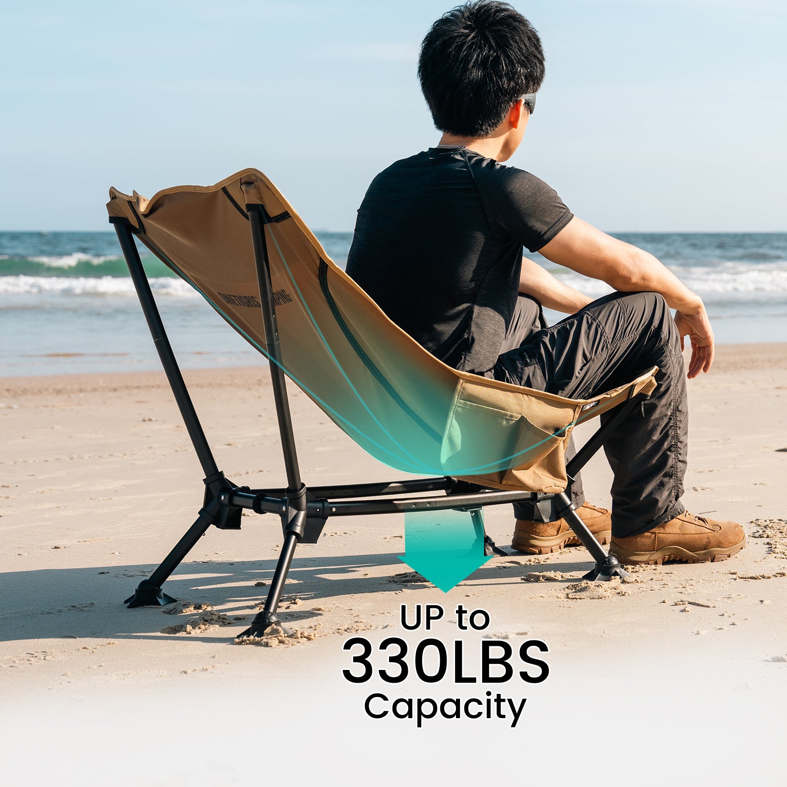 Person sitting on a portable chair on a beach with text indicating weight capacity.